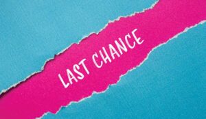 Last chance words written on ripped blue paper with pink background.