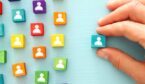 An image of colorful blocks with people icons over wooden table - WFM concept