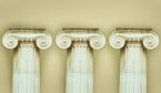 3 antique pillars stood on a yellow background