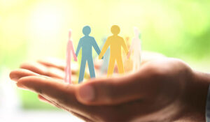 Group of people as paper cut outs holding hands