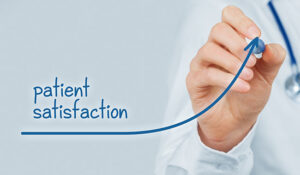 Person drawing a arrow that goes up with the word patient satisfaction on it