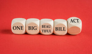 Red background with wooden blocks that say word by word 'One Big Beautiful Bill Act'