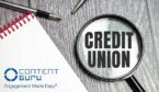 Credit Union. the inscription on magnifying glass on wooden background