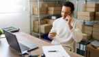 Entrepreneur multitasking in his small business warehouse: sipping coffee, chatting on the phone, and managing orders