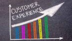 CUSTOMER EXPERIENCE written with chalk on tarmac over colourful graph and rising arrow