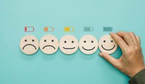 5 wooden blocks with different facial expressions from sad to happy