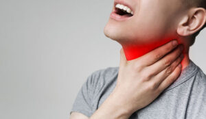 Person holding neck with red glow - lost voice concept