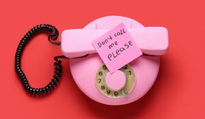 Pink retro telephone and sticker with text DON'T CALL ME PLEASE on red background
