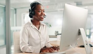 Contact centre worker in a headset working at a computer