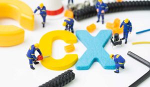 CX, Customer Experience concept, miniature figure worker building alphabet CX at the center