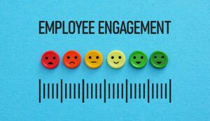 Employee engagement written on blue background with coloured faces showing emotions