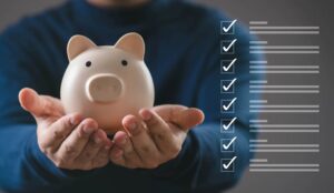 Hands holding a piggy bank with checklist icons, fundraising code of practice