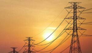 Transmission towers silhouetted against a setting sun