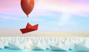 Red boat rising out of a crowd - differentiator concept