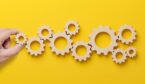A hand placing cogs - technology adoption and implementation concept