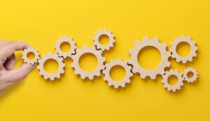 A hand placing cogs - technology adoption and implementation concept