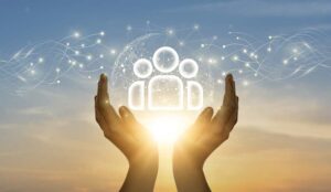 A pair of hands supporting people icons in sunlight