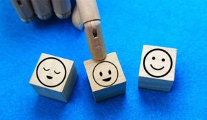 Robot putting finger on blocks with smiley faces on them