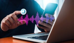 Voice technology concept with a person with a laptop and phone with sound wave and microphone icon
