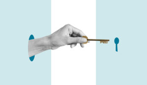 A hand holding a key heading towards a keyhold