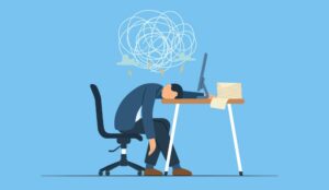Stressed worker with head on desk