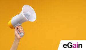 Hand holding a megaphone on colourful background - announcement concept