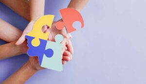 Hands holding jigsaw puzzle head shape creating inclusivity concept
